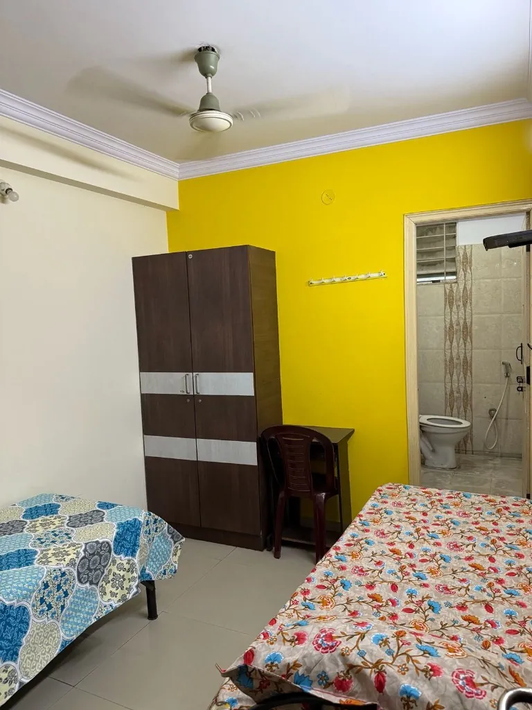 Twin-share room with desk and attached bathroom at Gayatri Luxury Ladies PG